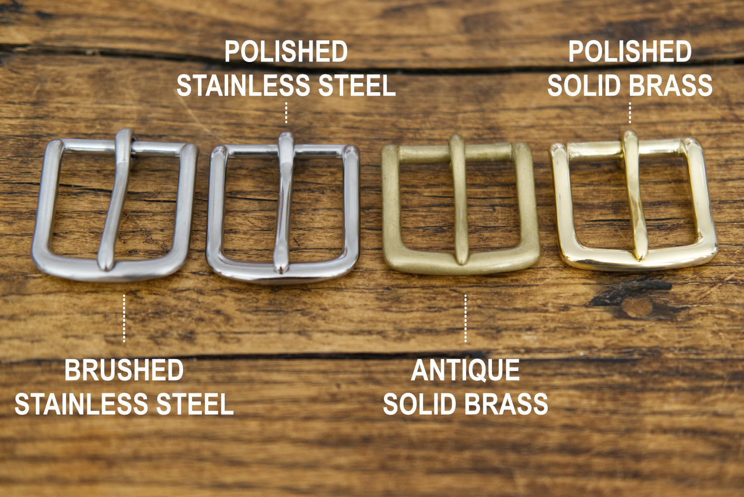 Four metal buckles labeled 'Polished Stainless Steel', 'Polished Solid Brass', 'Brushed Stainless Steel', and 'Antique Solid Brass' on a wooden background.
